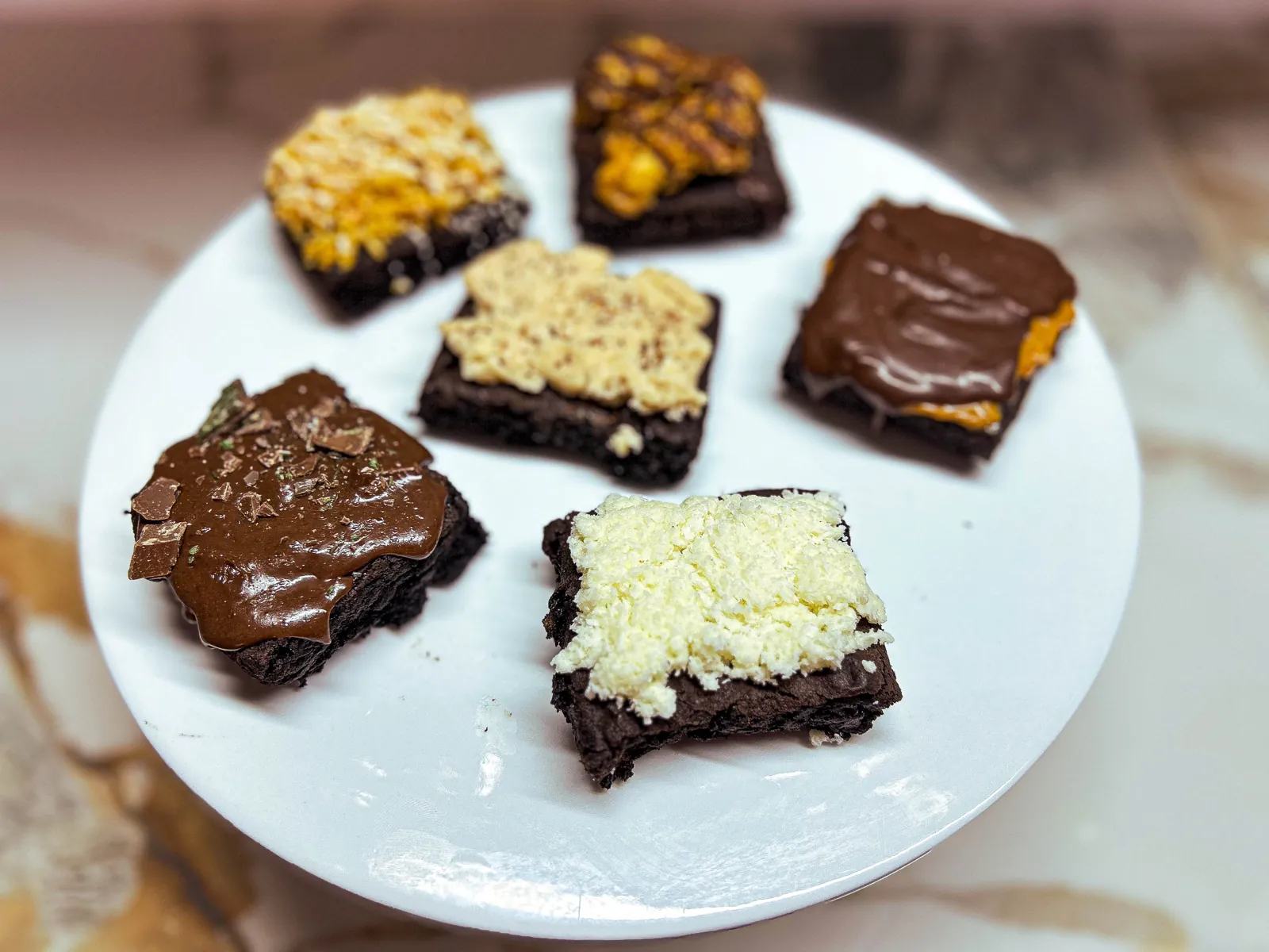 Fudgy brownie squares arranged on white marble