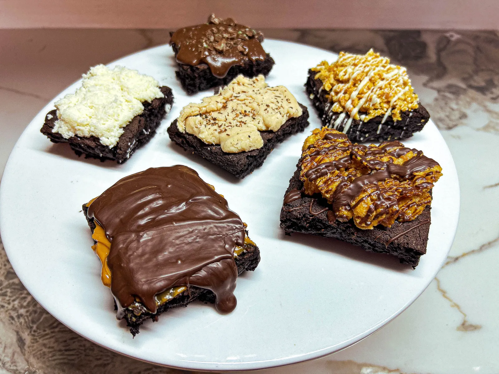 Side view of a plated brownie selection showing the fudgy crumb